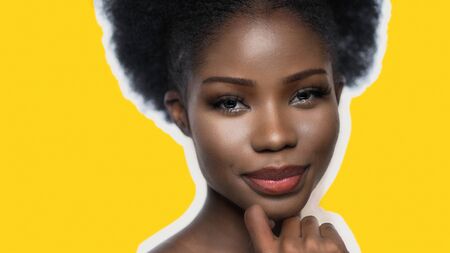 Sexy Afro Woman Isolated On Yellow Back With Copy Space On Left, Pretty Lady with Afro Hairstyle Looking At Camera Touching Face With Hand Close Upの写真素材