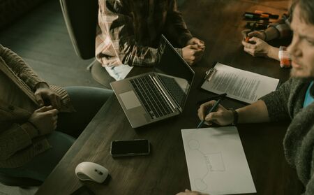 Group Of Business People Create Blueprint Plan For Resolving Situations, Close Up Hands Of Freelancers Team Working On Ideas At Table Using Laptop, Teamwork Concept, Top Viewの写真素材