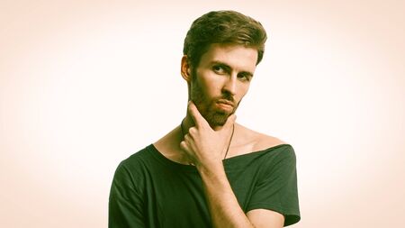 Serious Man Thoughtfully looking at camera, Portrait Of Macho Thinking And Touching His Bearded Chin...