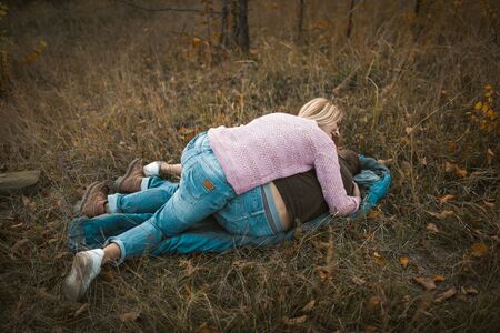 Cute Couple Fooling Around While Lying On Sleeping Bag At Grass, Blonde Woman Laughs Leaning On Her...