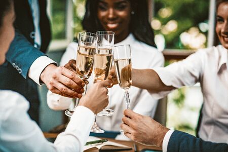 Diverse Team Combined Glasses With Champagne, Multi-Ethnic Group Of Colleagues Holding Glasses With Alcohol At Business Event, Well-Dressed Team Celebrating Successful Startup Project, Toned Imageの写真素材