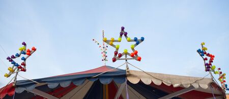 Star-shaped illuminations at the roof of carousel. Star-shaped lamp with multi-colored light bulbs....