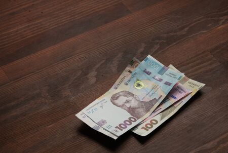 Pack of Ukrainian banknotes. New paper hryvnias different face value are on a brown wooden table. Cash money concept.の写真素材