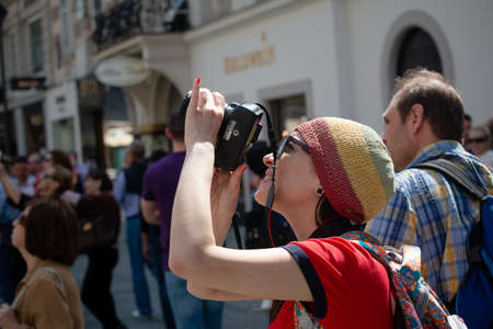 Female tourist makes photo of attractions on the street among the crowd. April, 2013. Vienna, Austria.のeditorial素材