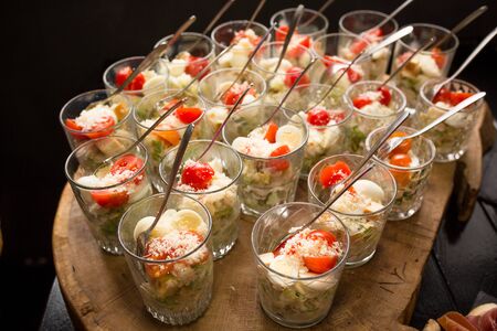 Fresh vegetable appetizer. Tasty salad in glasses. Festive treat concept. Catering banquet in cafe. High angle view.の写真素材