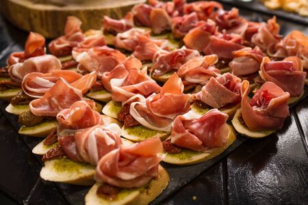 Bruschettas with ham or parma. Snack baguette with meat. Antipasto concept. Catering food concept. Close up shot.の写真素材