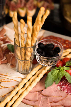Prosciutto and meat assorted. Breadsticks with meat slicing. Close up shot. Holiday or event treats. Catering food concept.の写真素材
