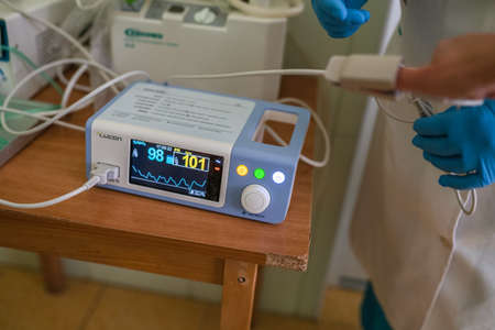 Doctor measures heart rate and oxygen saturation level in patient blood. Medical equipment. Human...