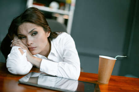 Tired or bored business woman relax at workplace. Young Caucasian woman rest at office table with...