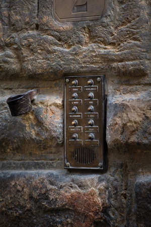 Vintage intercom at old stone building wall. Close up shot. May, 2013. Pisa, Italy.