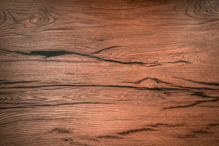 Wooden board with dark cracks close-up. Background image of wooden coating. High quality photo.