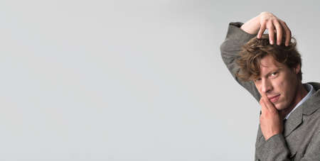 Pencive shaggy man puts his head with hands generating idea. Thinker concept. Copy space on left...