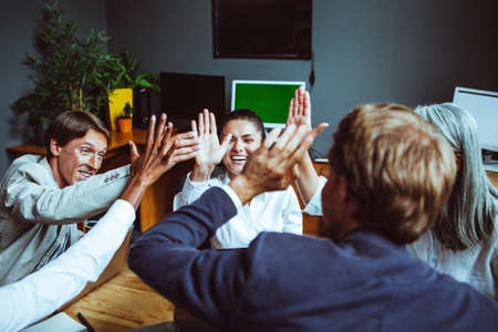 Business people giving each other high five and clapping. Business team celebrating success. High...