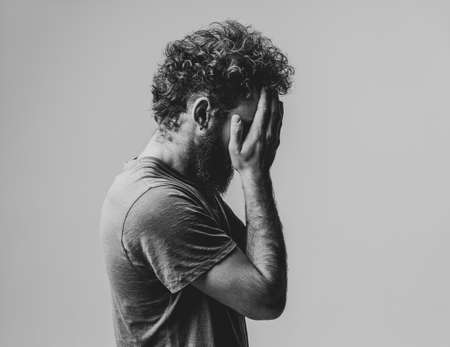 Drama, crisis, tired exhausted man cover face with his hands. Lost face young man woke up in the...