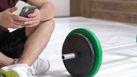 Sending a text messages or replying email young man sitting on a floor with black and green tone...