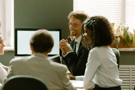 Group of young multi ethnic business people meeting for a presentation or brainstorm, financial analysis or marketing plans for next year. Attractive business people discussing ideas.の写真素材
