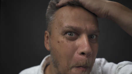 Middle-aged man quickly gets up and smiles defiantly at the camera. Man prepares for dating concept....