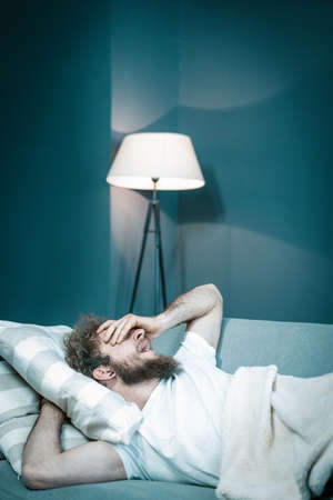 Caucasian Guy Wants to Sleep But Cannot Because of Noisy Neighbors. Tired Man Lies in His Bed and...