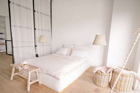 pale pink bedroom in a minimalistic style with a double bed with areas for clothes and for sleeping. High quality photoの写真素材
