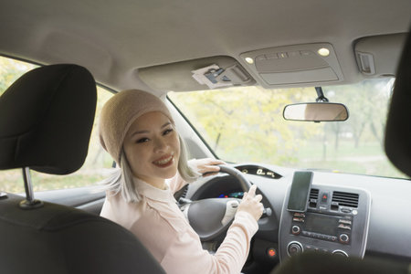 Portrait asian woman looking over the seat to back of the car. Mature asian woman looking at the...