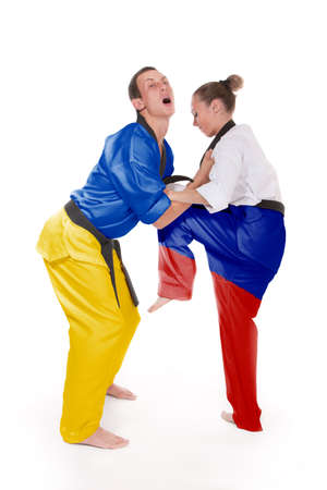 Attack kick, Russia and Ukraine two fighting representatives of different countries. Woman make ankle kick to a man, two fighting people isolated on white background.の写真素材