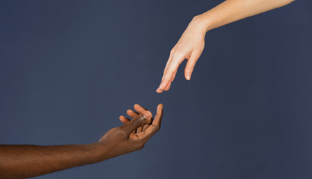 Interracial communication and cooperation of human being. Black and white male and female hands isolated on blue background. BLM concept. All Lives matter concept.の写真素材