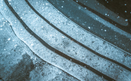 Sharp and clean lines of black and white stripes formed by ice and snow. The monochromatic color scheme creates striking contrast and pattern. High quality photoの写真素材