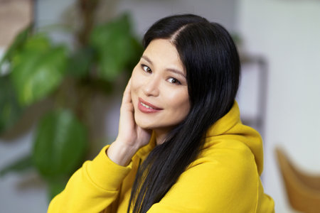 Pretty middle-aged Asian woman with healthy, glowing facial skin and well-groomed hair, promoting concept of healthy lifestyle. Woman radiates confidence, vitality, and well-being, in harmony with nature and her surroundings. High quality photoの写真素材