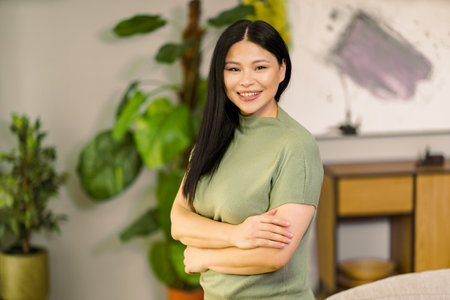 Middle-aged woman smiles with vibrant energy at home, embodying the concepts of healthy lifestyle and biohacking, promoting wellness and self-care. High quality photoの写真素材