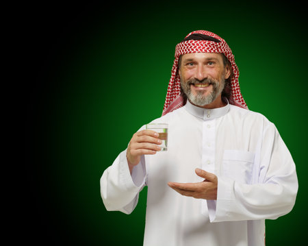 Arab man holding glass of water, conveying sense of healthy living and mindfulness. It emphasizes importance of hydration and wellness in Middle Eastern culture, making it ideal for use in health. High quality photoの写真素材