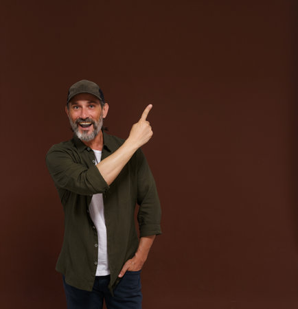 Advertising concept, mature European caucasian man pointing his finger to side. Hunter advertising concepts, marketing strategies, business communication scenario. High quality photoの写真素材