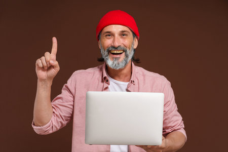 Available information on the concept network. Eureka. Quick search for solution. man holds laptop and pointing up with finger of other hand, symbolizing eureka moment of finding quick solution through online networks and digital technology. High quality photoの写真素材