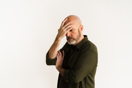 Man making facepalm gesture, expressing frustration and disappointment. Concept of problems and challenges depicted through gesture and facial expression, conveying sense of stress and exasperation. . High quality photoの写真素材