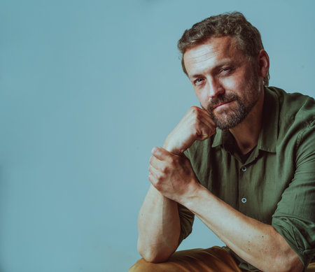 Handsome mid-aged man portrayed in confident and professional manner. With his hands crossed and a composed expression, he exudes a sense of reliability and trustworthiness. . High quality photoの写真素材