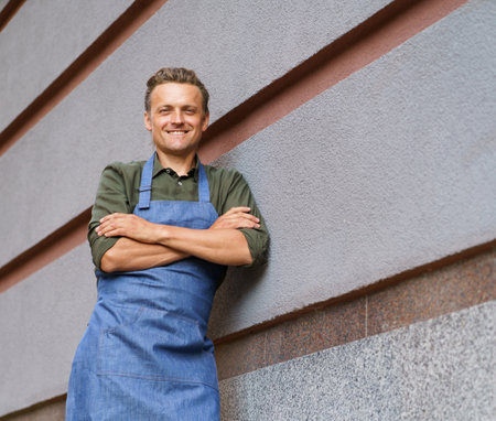 Waiter or service man positioned against a restaurant wall. With a professional demeanor, the individual exudes confidence and embodies the core values of hospitality and customer service. . High quality photoの写真素材