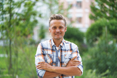 Man on the street with crossed hands, exuding a sense of confidence and composure. With a relaxed posture and a calm demeanor, he navigates the urban environment with ease. High quality photoの写真素材