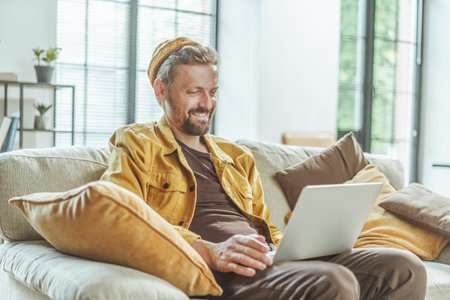 Happy client watches the result of freelancers work on computer. Man with focused attention, he views outcome of the freelancers efforts displayed on computer screen. . High quality photoの写真素材