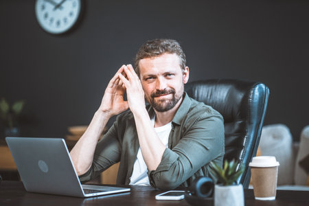 Confident businessman, exuding professionalism and leadership, makes pivotal decision based on meticulous computer analysis data. With hands folded in contemplative gesture, he gazes directly at camera. High quality photoの写真素材