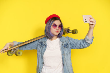 Trendy Teenager In Casual Wear Captures Selfie With Longboard Or Skateboard, Showcasing Blend Of Modern Lifestyle, Fashion, And Youth Culture. Trendy Attire And Activities Associated With Contemporary Teenagers. High quality photoの写真素材
