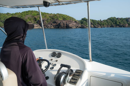 Person Piloting a White Motorboat Towards a Rocky Tropical Island