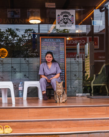 Woman in Scrubs with a Cat Outside a Spa in Baliのeditorial素材