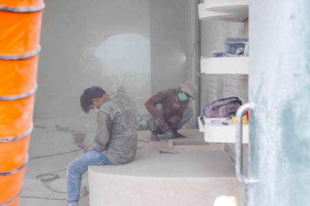 Builders Shaping Masonry in Hazy Interior