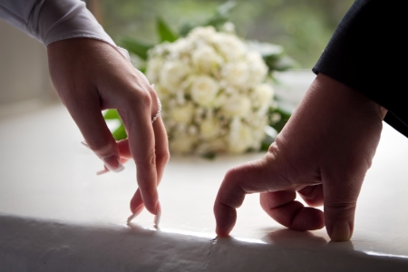 Hands newlyweds portrayed the proposal process on the background of the bouquetの写真素材