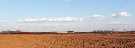 Passenger train rides among the fieldの写真素材