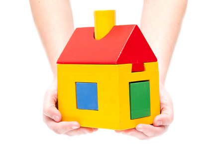 Toy house in hands on white の写真素材