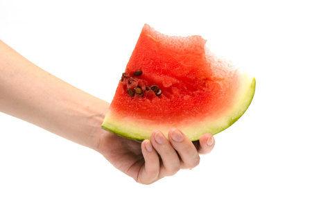 Hand holding a slice of watermelonの写真素材