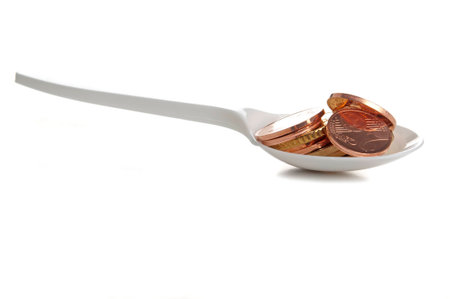 Coins in plastic spoon on white background