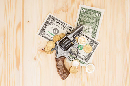 Gun and money on wooden backgroundの写真素材