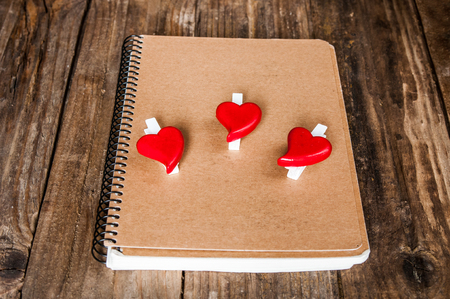 Notepad and hearts on grunge wooden backgroundの写真素材