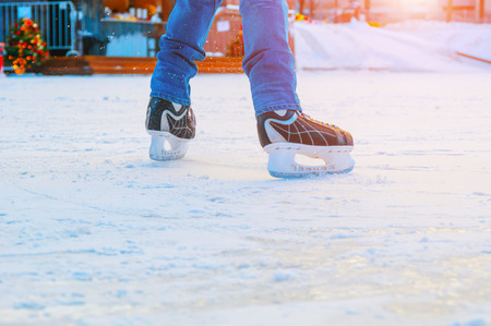 Feet of skater at skating rink in sunset